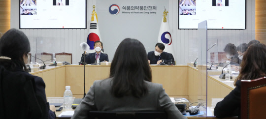 4일 오후 충북 청주시 식품의약품안전처에서 열린 아스트라제네카의 코로나19 백신 허가 관련 중앙약사심의위원회 자문회의에서 오일환 위원장(왼쪽 두번째)을 비롯한 참석자들이 자료를 살피고 있다. <청주=연합뉴스>